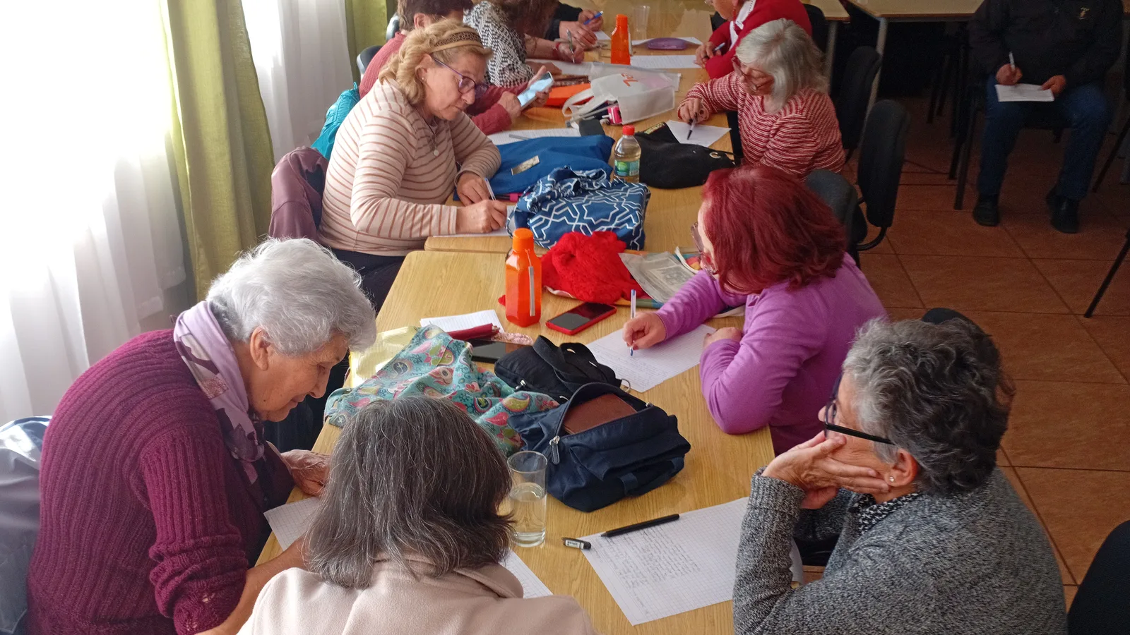 Personas mayores trabajando en grupo alrededor de una mesa durante el taller